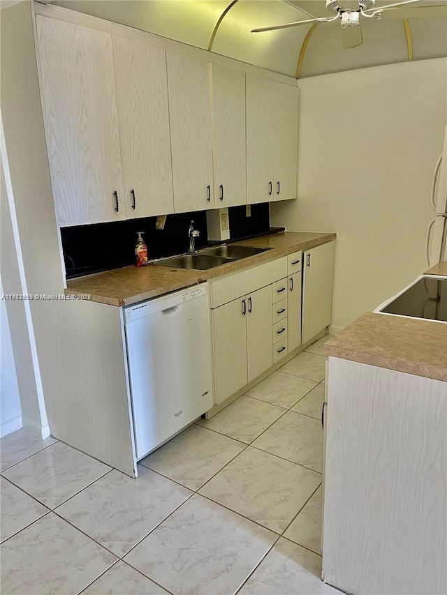 kitchen with cream cabinets, white dishwasher, and sink