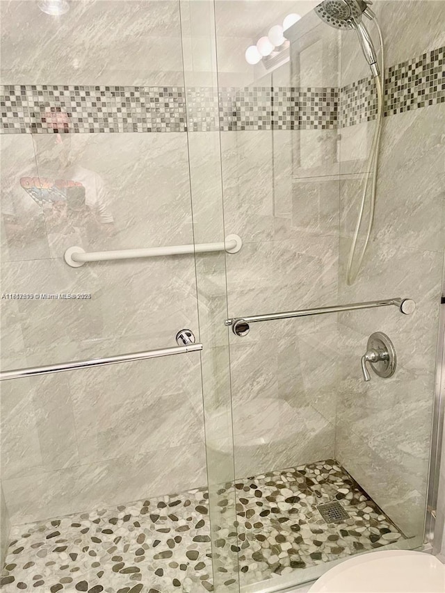 bathroom with toilet and a shower with door