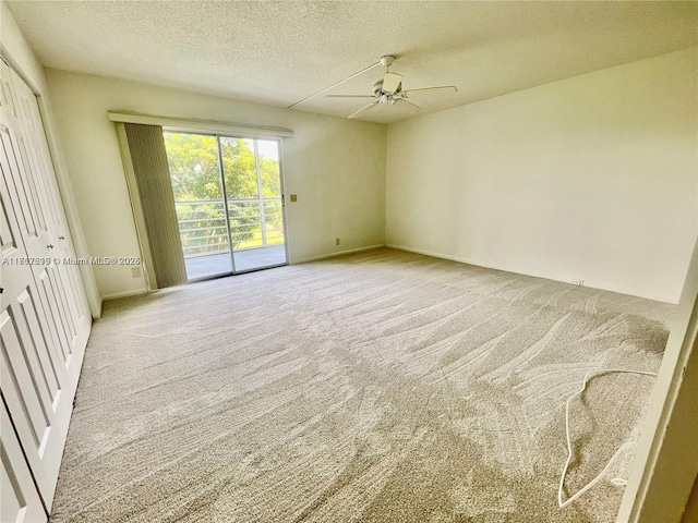 carpeted spare room with ceiling fan and a textured ceiling