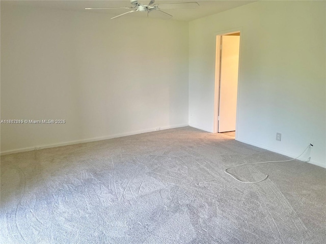 carpeted spare room with ceiling fan