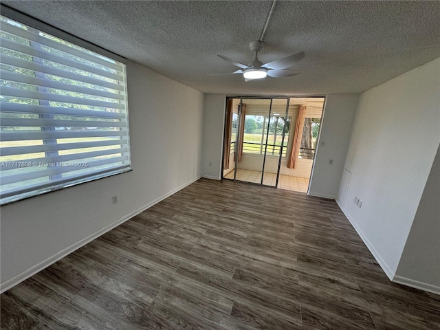 empty room featuring a textured ceiling, dark hardwood / wood-style flooring, and ceiling fan