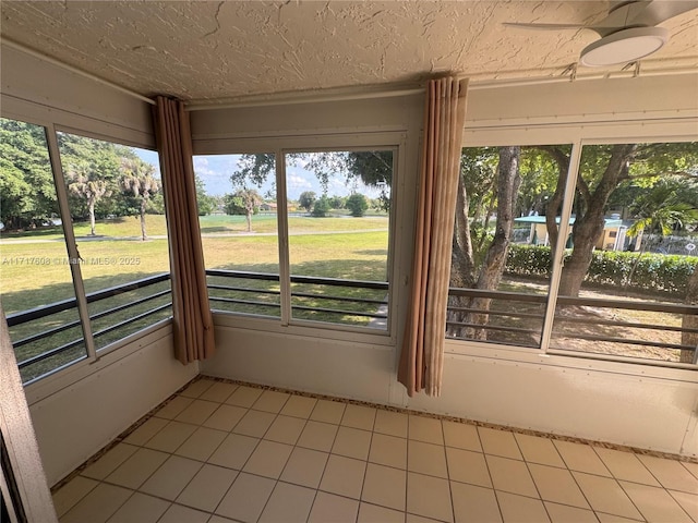 unfurnished sunroom featuring ceiling fan