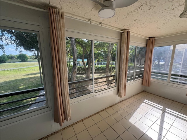 unfurnished sunroom featuring ceiling fan