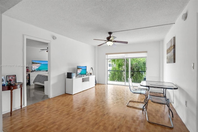 living room with a textured ceiling and ceiling fan