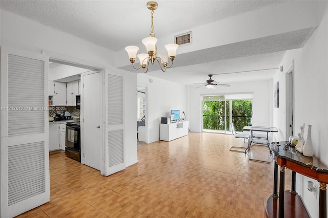 interior space with a textured ceiling, light tile patterned floors, and ceiling fan with notable chandelier