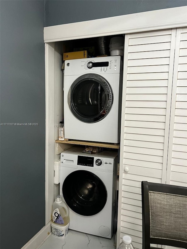 laundry room featuring stacked washer / drying machine