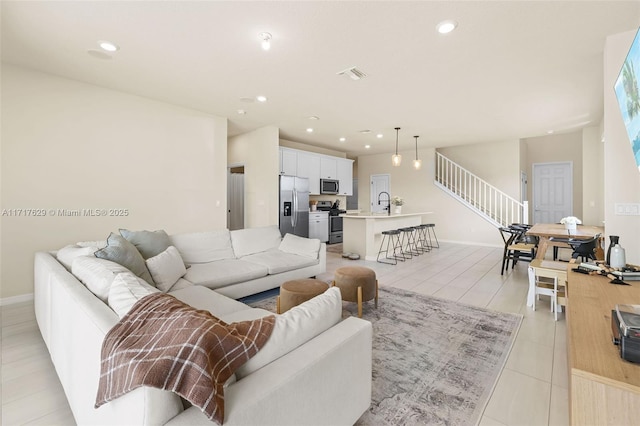 living room featuring sink and light tile patterned flooring