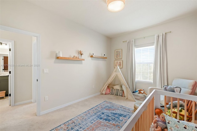 bedroom featuring light colored carpet and a nursery area