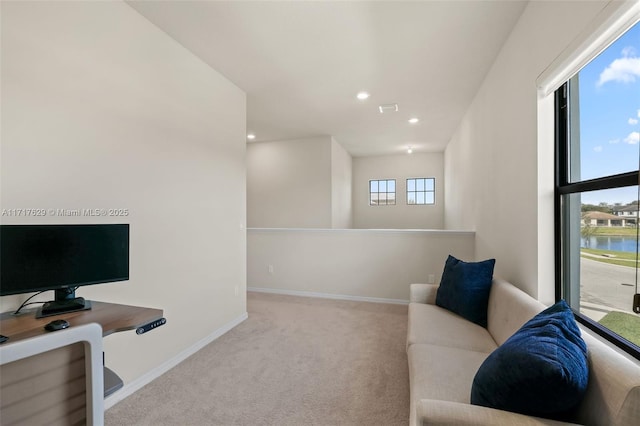 carpeted living room featuring a water view