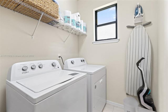 clothes washing area featuring light tile patterned floors and independent washer and dryer