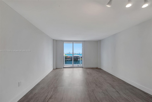 unfurnished room featuring a water view and floor to ceiling windows