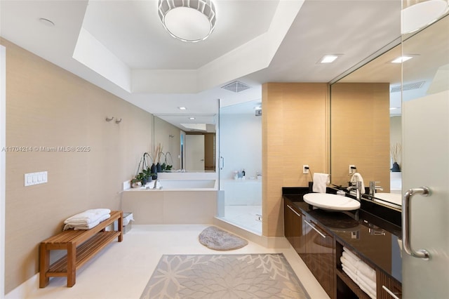 bathroom featuring shower with separate bathtub, vanity, and a tray ceiling