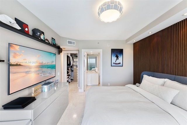 tiled bedroom featuring ensuite bathroom and a closet