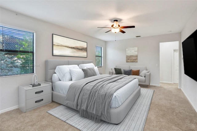 bedroom with ceiling fan and light carpet