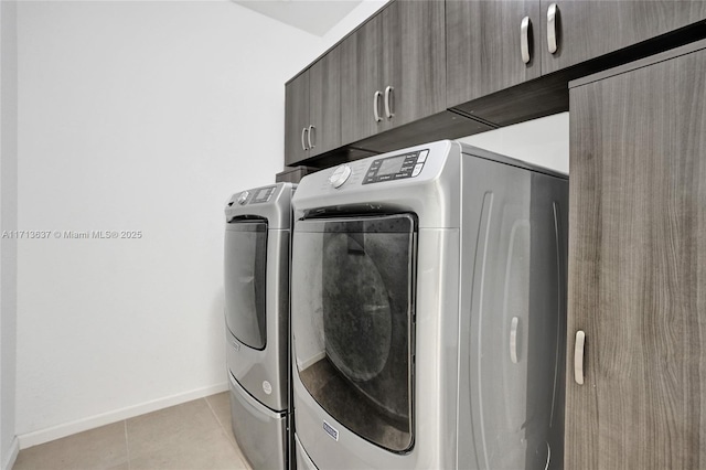 washroom featuring cabinets, light tile patterned floors, and separate washer and dryer