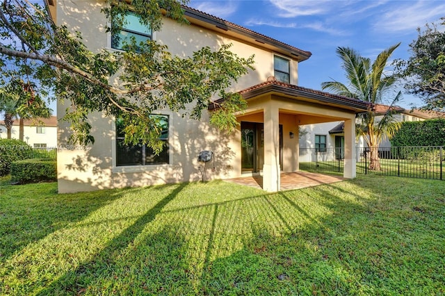 rear view of property featuring a patio area and a yard