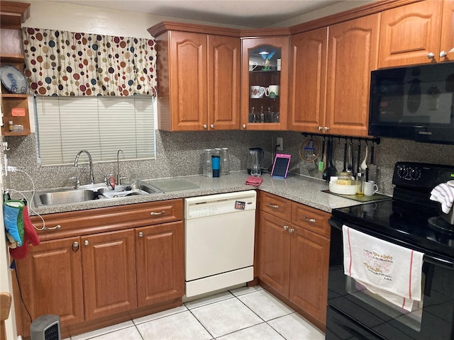 kitchen featuring black appliances, light tile patterned floors, sink, and tasteful backsplash