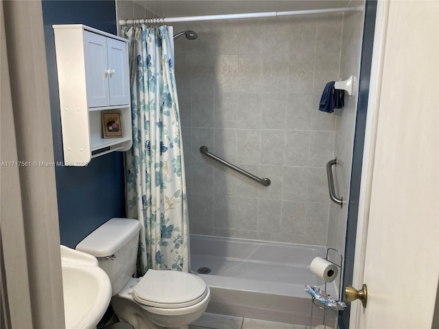 bathroom featuring toilet, sink, and curtained shower