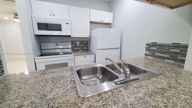 kitchen with tasteful backsplash, sink, white cabinets, and white appliances