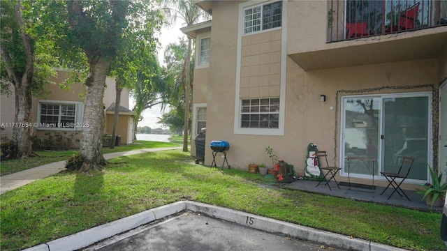 view of side of home with a patio area and a yard