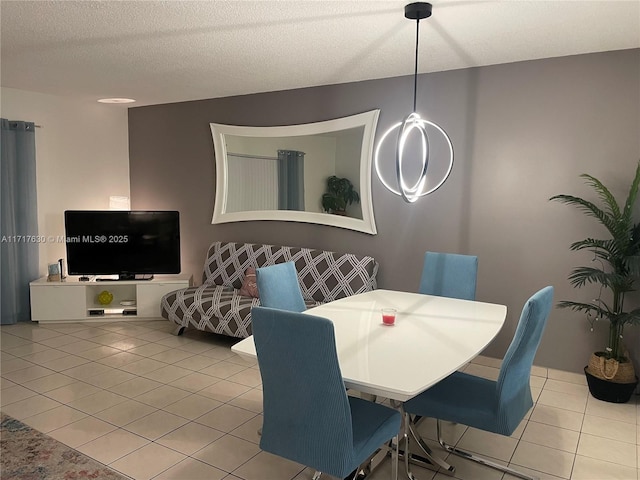 dining space with light tile patterned floors and a textured ceiling