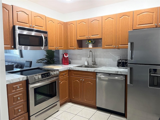 kitchen with appliances with stainless steel finishes, tasteful backsplash, light tile patterned floors, and sink