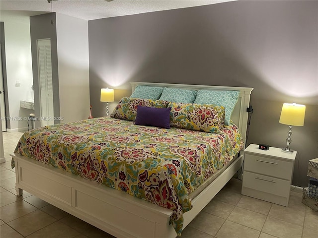 bedroom featuring light tile patterned floors and a textured ceiling