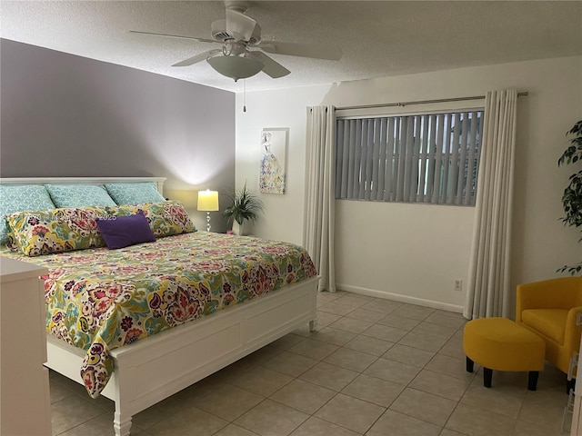 bedroom with ceiling fan, light tile patterned floors, and a textured ceiling