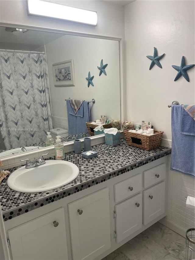 bathroom with vanity, curtained shower, and toilet