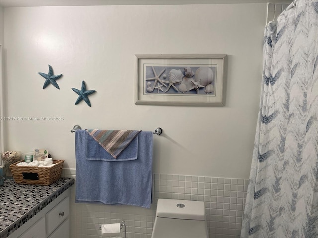 bathroom featuring a shower with curtain, vanity, toilet, and tile walls