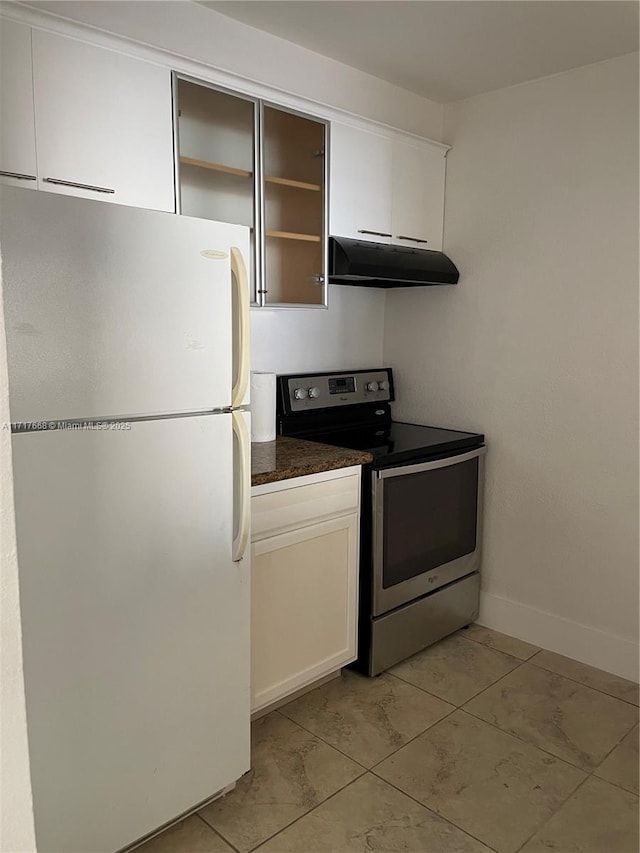 kitchen with light tile patterned floors, white refrigerator, white cabinetry, and stainless steel electric range