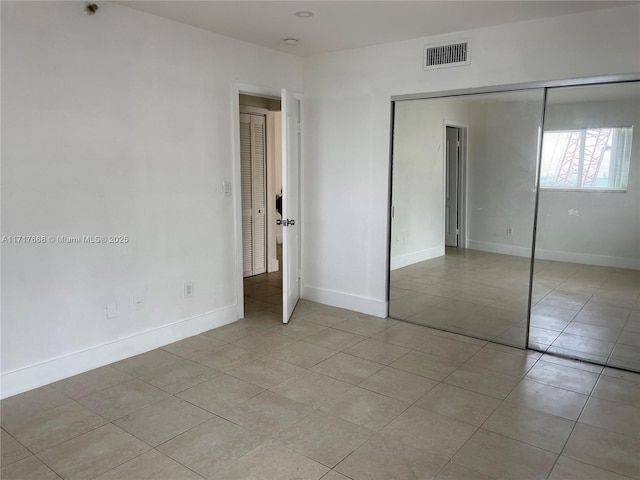 unfurnished bedroom with a closet and light tile patterned flooring