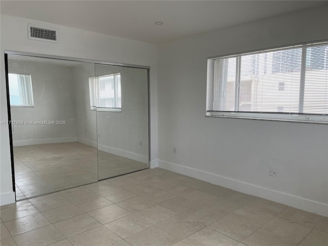 unfurnished bedroom with a closet and light tile patterned flooring