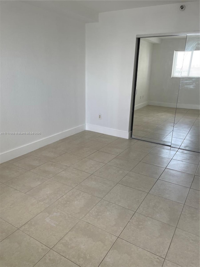 unfurnished bedroom featuring light tile patterned floors and a closet