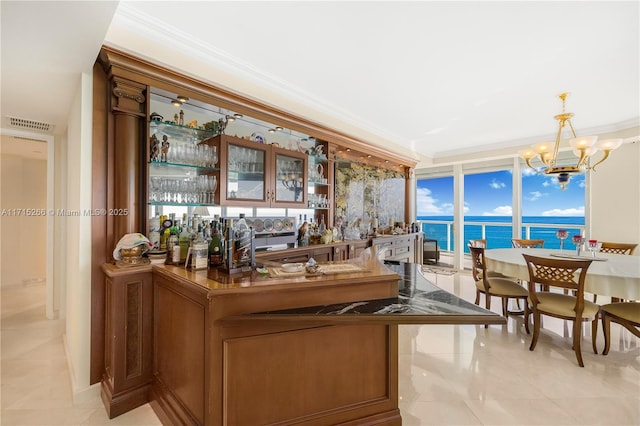 bar with pendant lighting, a water view, floor to ceiling windows, and ornamental molding