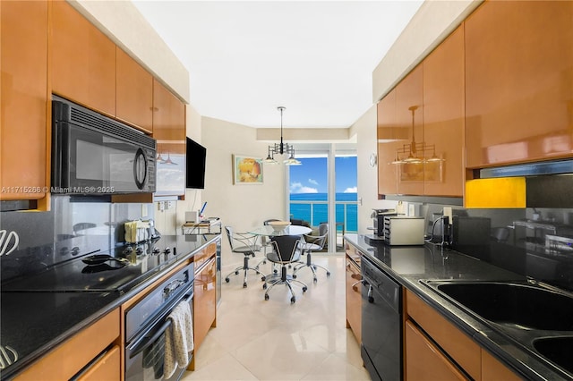 kitchen featuring tasteful backsplash, black appliances, decorative light fixtures, a notable chandelier, and light tile patterned flooring