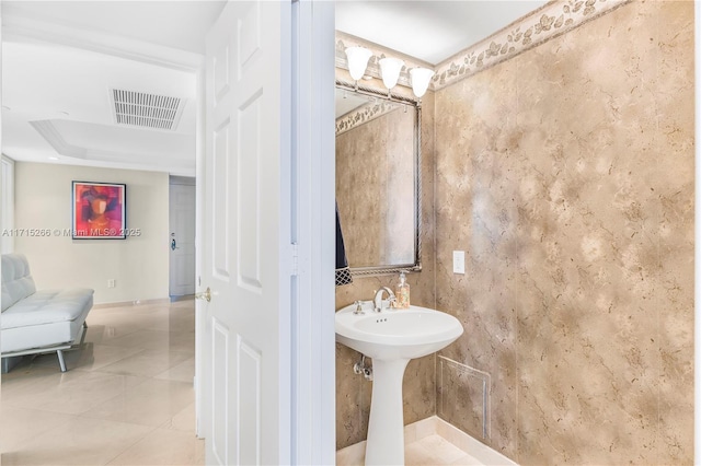 bathroom with a raised ceiling, tile patterned flooring, and sink