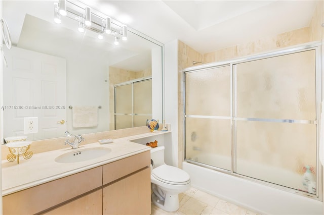 full bathroom with tile patterned floors, vanity, toilet, and bath / shower combo with glass door