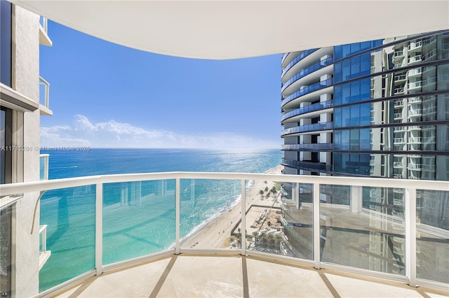 balcony featuring a water view and a beach view