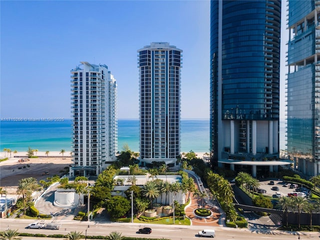 property's view of city featuring a water view and a beach view