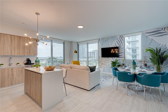 living room featuring a chandelier, floor to ceiling windows, and sink