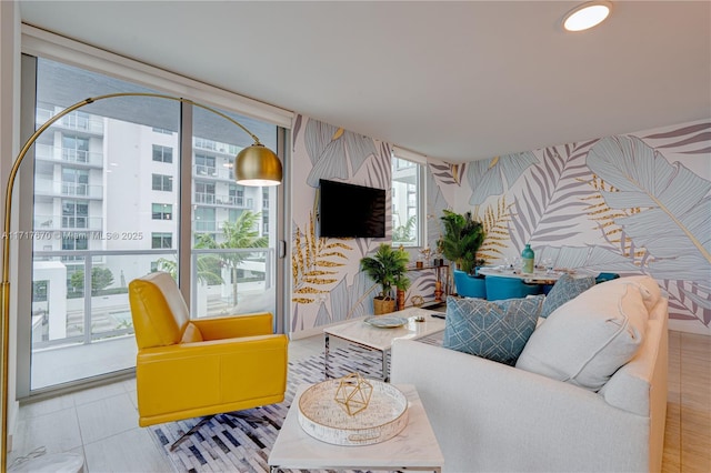 living room with light tile patterned floors and a wall of windows