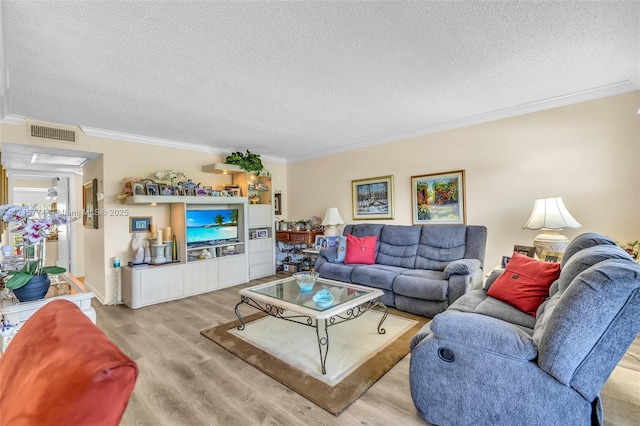 living room featuring a textured ceiling, light hardwood / wood-style floors, and crown molding