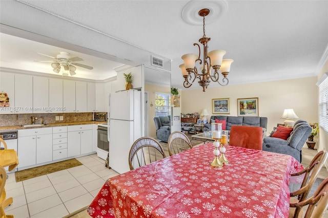 dining area featuring sink, light tile patterned flooring, ceiling fan with notable chandelier, and ornamental molding