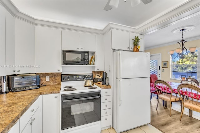 kitchen featuring white cabinets, white refrigerator, and electric stove