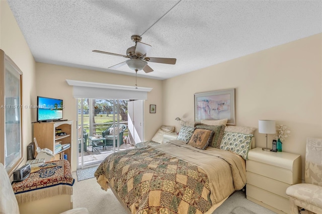 carpeted bedroom with ceiling fan, access to exterior, and a textured ceiling