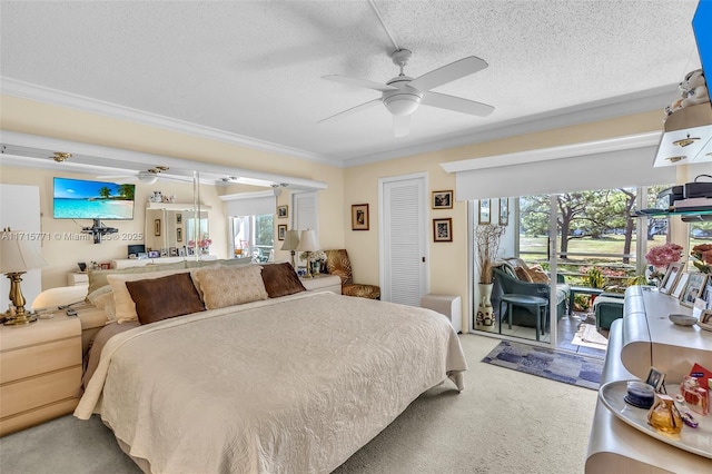 carpeted bedroom featuring access to outside, ceiling fan, ornamental molding, a textured ceiling, and a closet