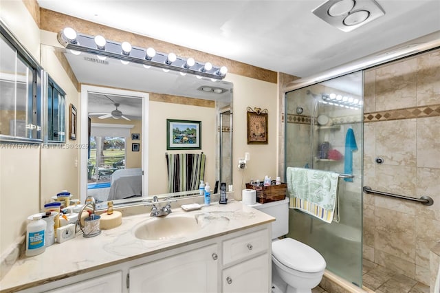 bathroom featuring ceiling fan, a shower with door, vanity, and toilet