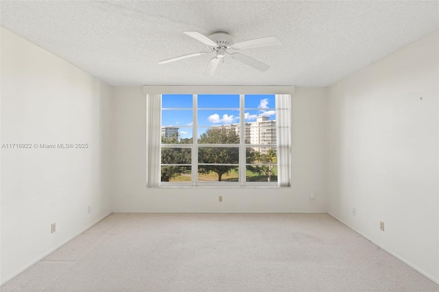 carpeted empty room featuring ceiling fan and a textured ceiling