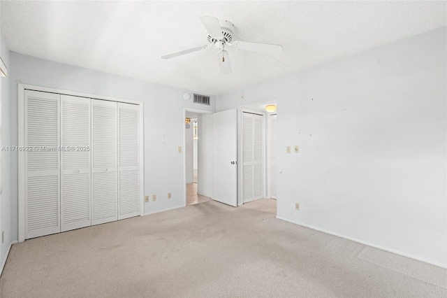 unfurnished bedroom featuring light carpet and ceiling fan